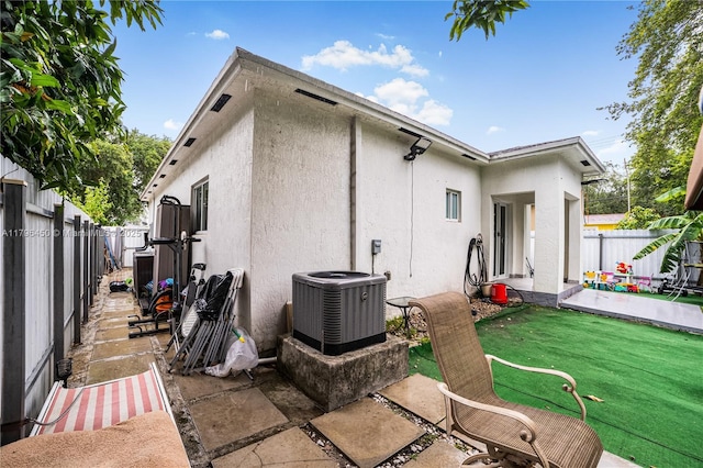1793 NW 93rd Ter, Miami, FL 33147 - rear view of property with stucco siding, a lawn, a fenced backyard, and central AC