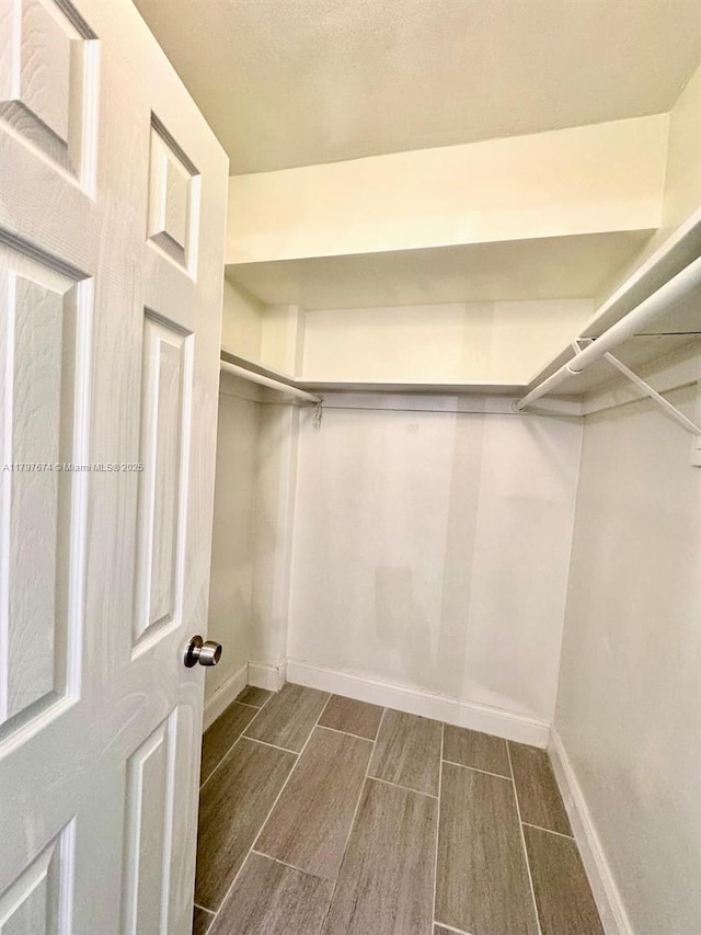 walk in closet with wood tiled floor