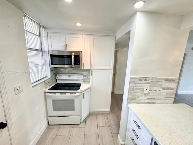 kitchen with white cabinetry, white electric range, and stainless steel microwave
