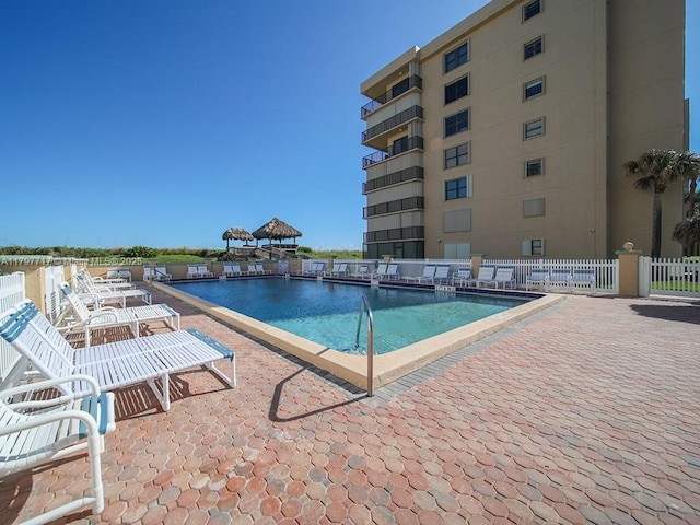 pool with fence and a patio area