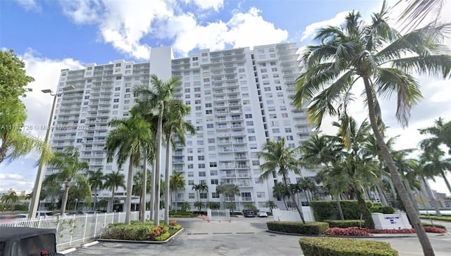 view of building exterior featuring uncovered parking and fence