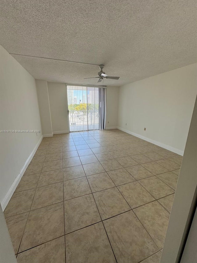unfurnished room featuring a textured ceiling, baseboards, ceiling fan, and light tile patterned flooring