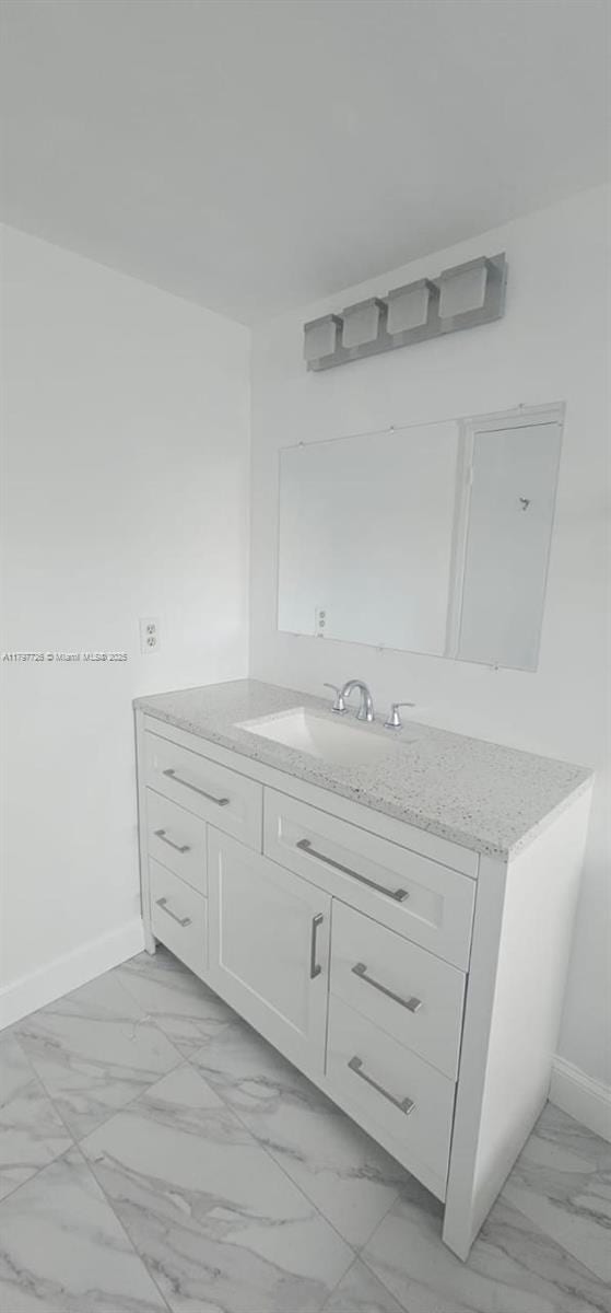 bathroom featuring vanity, baseboards, and marble finish floor