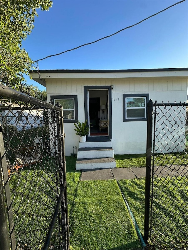 1874 NW 65th St, Miami, FL 33147 - view of front of home featuring entry steps, fence, and a gate