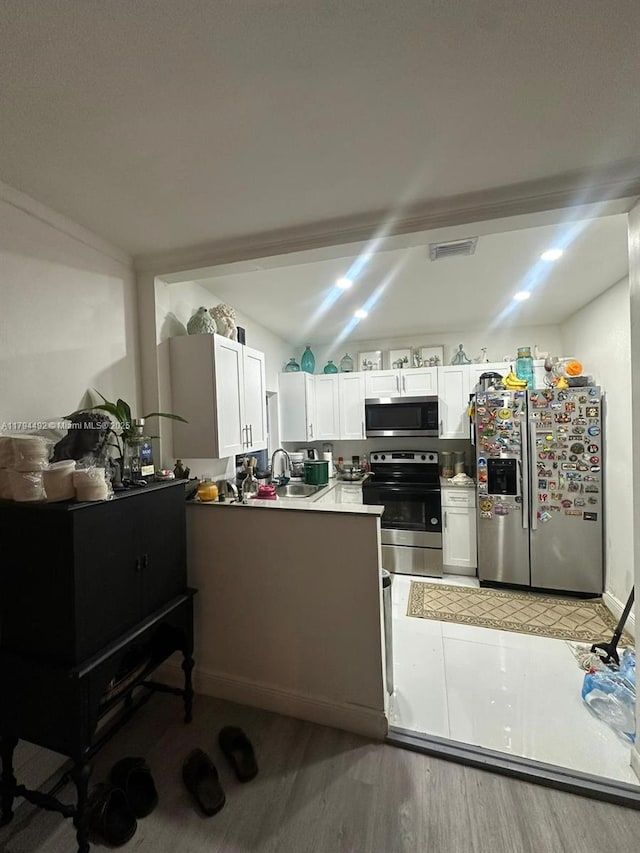 1874 NW 65th St, Miami, FL 33147 - kitchen with a peninsula, stainless steel appliances, white cabinets, and visible vents