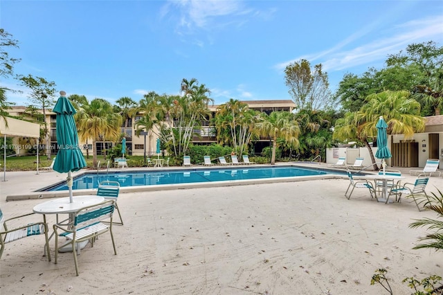 community pool with a patio and fence