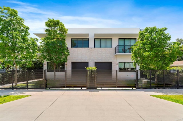 3132 Plaza St, Miami, FL 33133 - modern home with stucco siding, a fenced front yard, concrete driveway, an attached garage, and a balcony