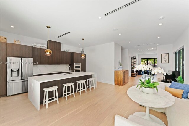 3132 Plaza St, Miami, FL 33133 - kitchen featuring stainless steel appliances, a sink, a kitchen breakfast bar, open floor plan, and light countertops