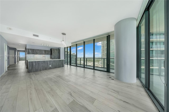 480 NE 31st St Unit 4307, Miami, FL 33137 - unfurnished living room with expansive windows, light wood-style flooring, and a chandelier