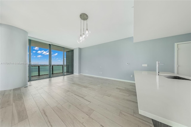 480 NE 31st St Unit 4307, Miami, FL 33137 - empty room featuring a wall of windows, baseboards, and light wood-type flooring