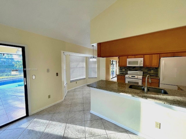 5400 NW Emblem St, Port St Lucie, FL 34983 - kitchen with white appliances, a sink, brown cabinetry, high vaulted ceiling, and tasteful backsplash