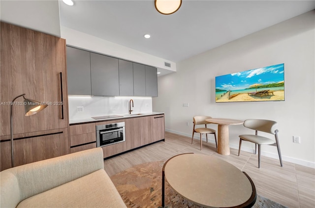 580 72nd St Unit 1511, Miami Beach, FL 33141 - kitchen with baseboards, light wood finished floors, visible vents, a sink, and oven