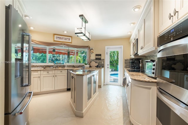 610 Lake Dasha Cir, Plantation, FL 33324 - kitchen featuring appliances with stainless steel finishes, tasteful backsplash, light stone counters, recessed lighting, and hanging light fixtures