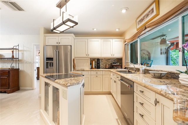 610 Lake Dasha Cir, Plantation, FL 33324 - kitchen featuring stainless steel appliances, light stone countertops, tasteful backsplash, hanging light fixtures, and glass insert cabinets