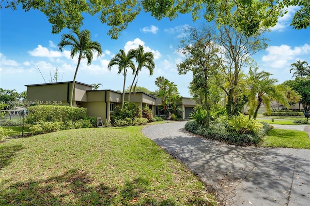 610 Lake Dasha Cir, Plantation, FL 33324 - view of front facade with stucco siding, driveway, and an attached garage