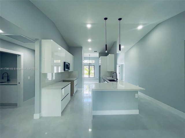 kitchen featuring stainless steel microwave, a sink, white cabinets, modern cabinets, and concrete floors