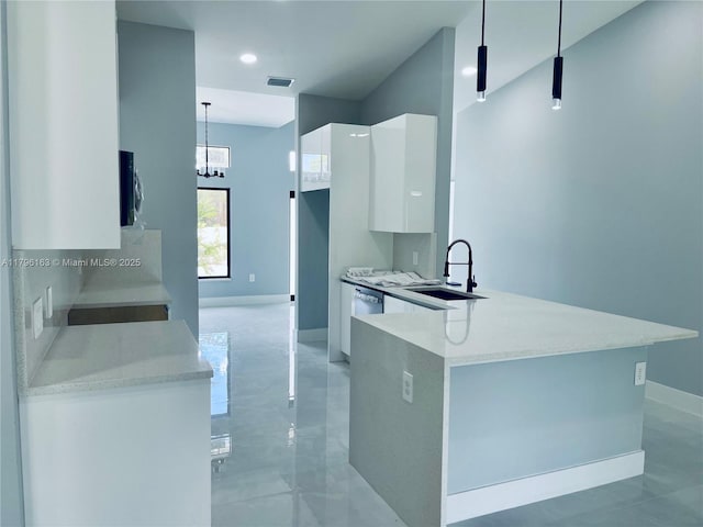 kitchen with baseboards, modern cabinets, a sink, white cabinetry, and light countertops