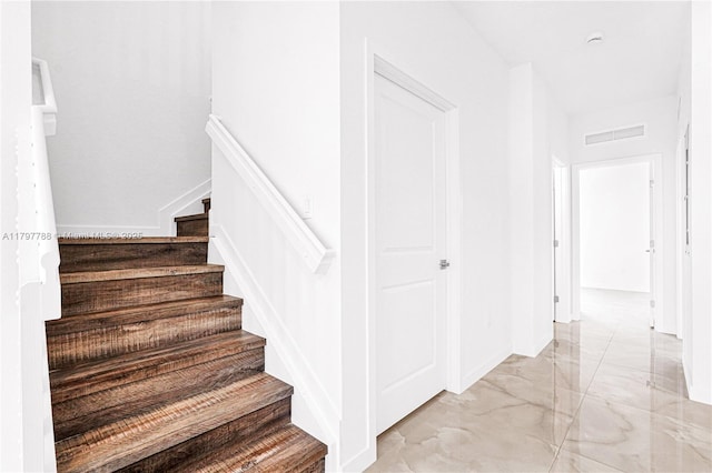 stairs with marble finish floor and visible vents