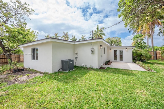10051 SW 48th St, Miami, FL 33165 - back of property with french doors, stucco siding, fence, central AC unit, and a yard