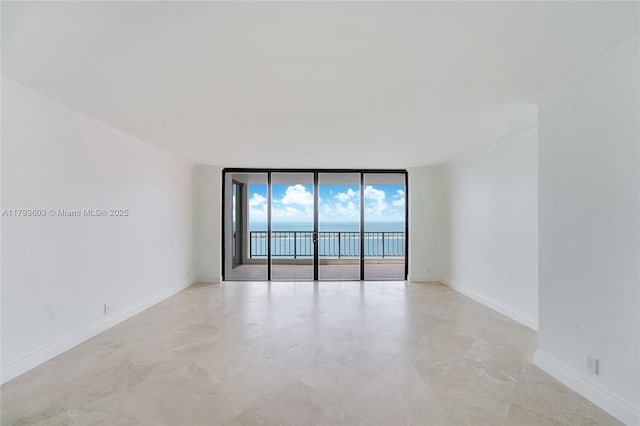 1581 Brickell Ave Unit Ph102, Miami, FL 33129 - spare room featuring crown molding, a wall of windows, and baseboards