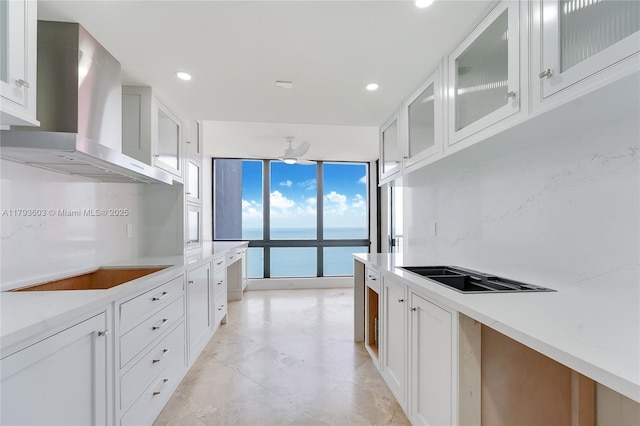 1581 Brickell Ave Unit Ph102, Miami, FL 33129 - kitchen with wall chimney range hood, black electric cooktop, a water view, light countertops, and white cabinets