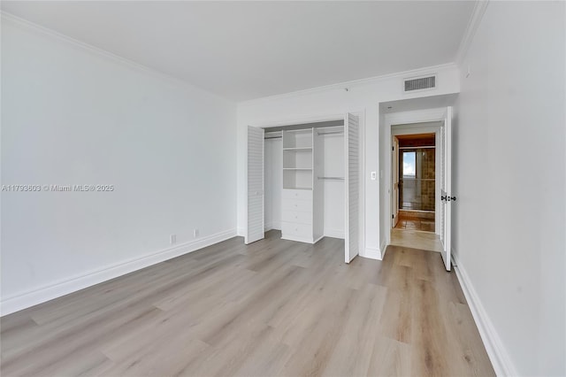 1581 Brickell Ave Unit Ph102, Miami, FL 33129 - unfurnished bedroom with a closet, light wood-style flooring, baseboards, visible vents, and crown molding
