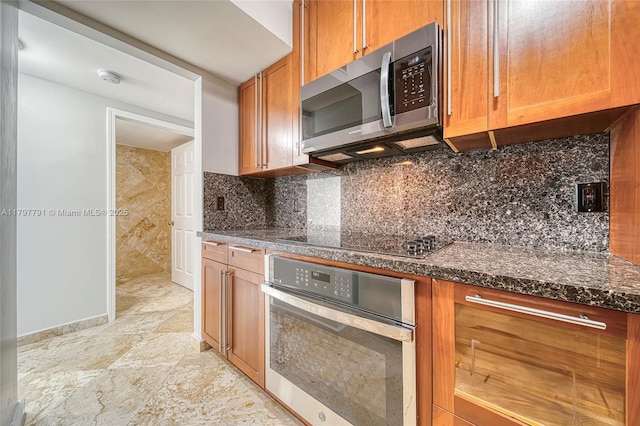 8888 Collins Ave Unit 201, Surfside, FL 33154 - kitchen with appliances with stainless steel finishes, tasteful backsplash, brown cabinets, and dark stone counters