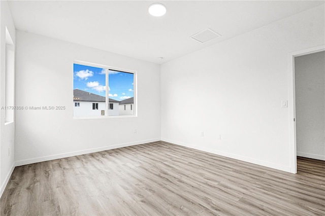 empty room featuring wood finished floors and baseboards