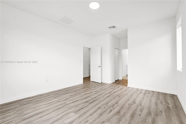 unfurnished bedroom with a closet, visible vents, light wood-style flooring, and baseboards