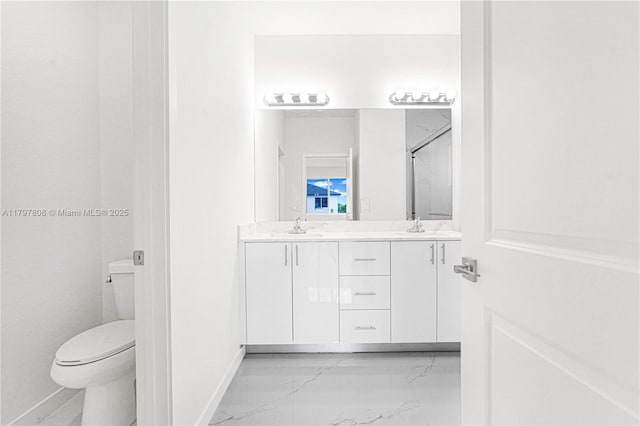 full bathroom featuring toilet, marble finish floor, baseboards, a sink, and double vanity