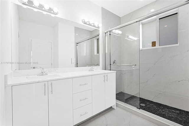bathroom featuring a marble finish shower, marble finish floor, double vanity, and a sink