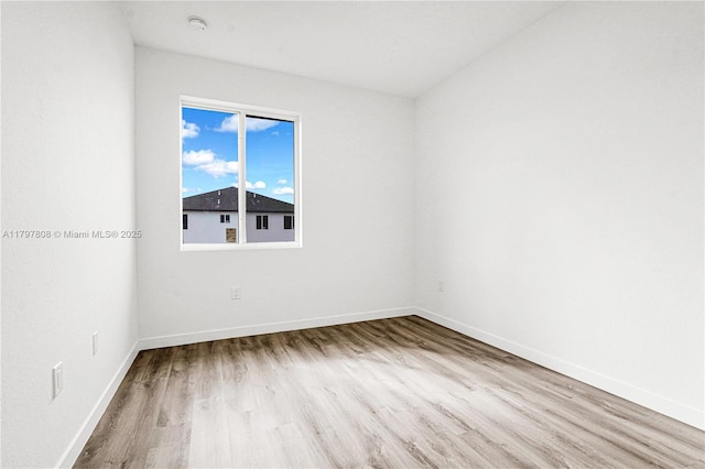 unfurnished room with baseboards and wood finished floors