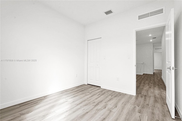 unfurnished bedroom with recessed lighting, baseboards, visible vents, and wood finished floors