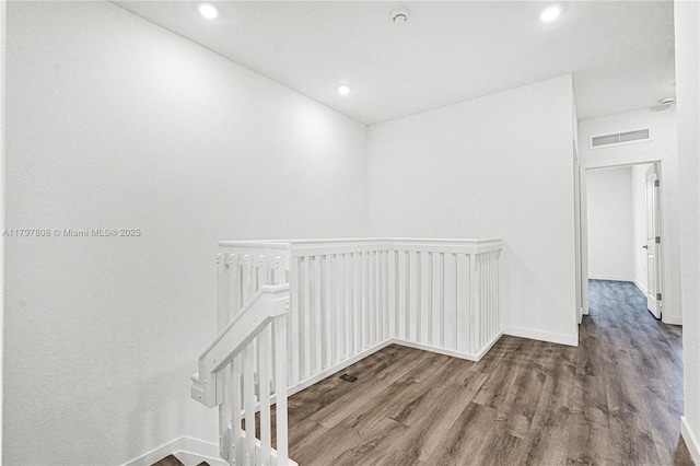 hall featuring recessed lighting, an upstairs landing, visible vents, and wood finished floors