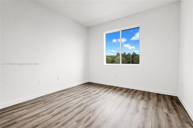 unfurnished room featuring wood finished floors and baseboards