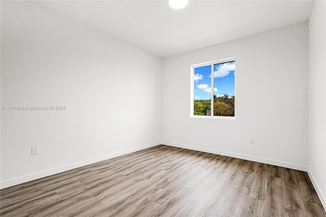 unfurnished room with wood finished floors and baseboards