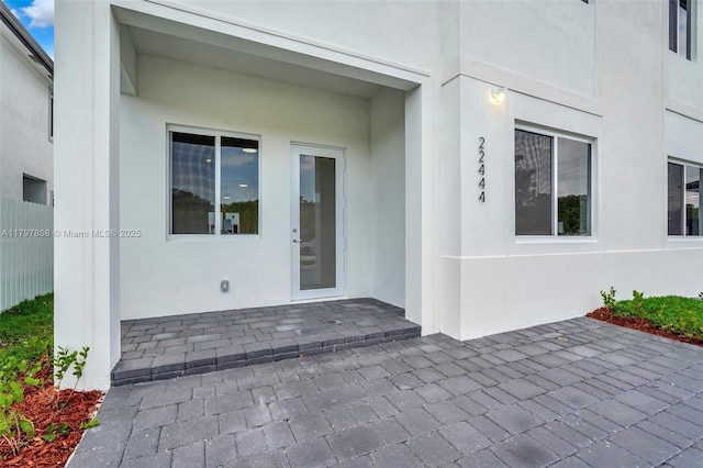 entrance to property with a patio area and stucco siding
