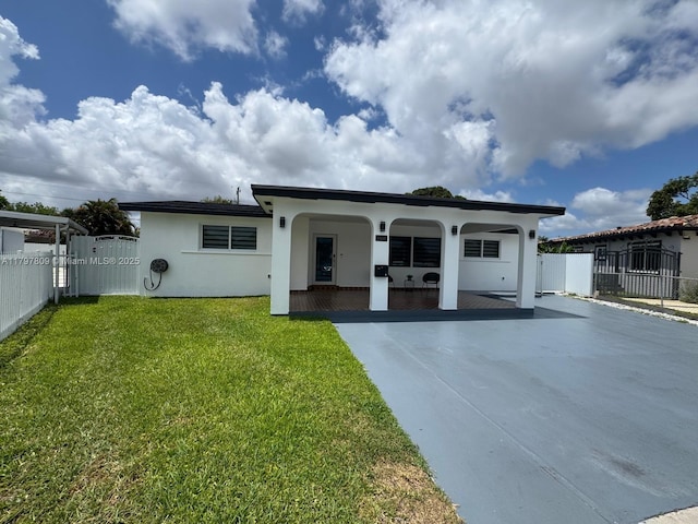 view of front of house featuring stucco siding, a front lawn, fence, and a gate