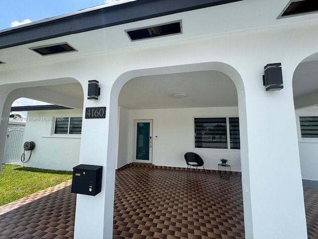 property entrance with stucco siding and visible vents