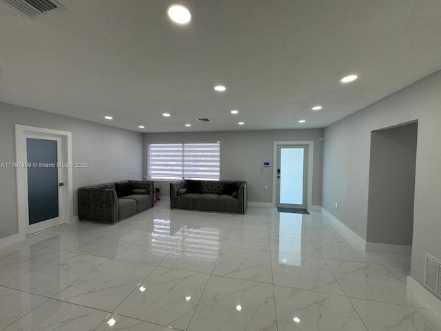 unfurnished living room featuring marble finish floor, baseboards, visible vents, and recessed lighting