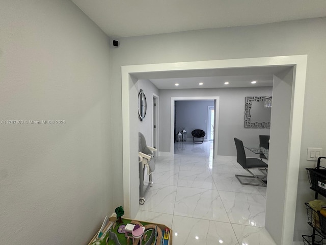 hallway with baseboards, marble finish floor, and recessed lighting