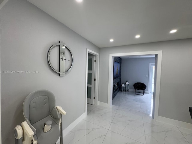 corridor featuring baseboards, marble finish floor, and recessed lighting