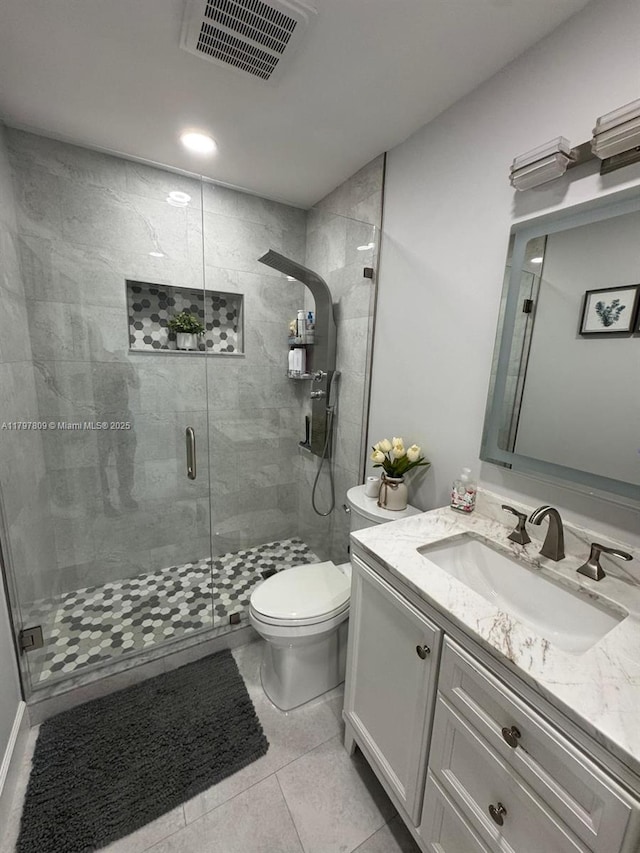 full bathroom with toilet, vanity, visible vents, tile patterned flooring, and a shower stall