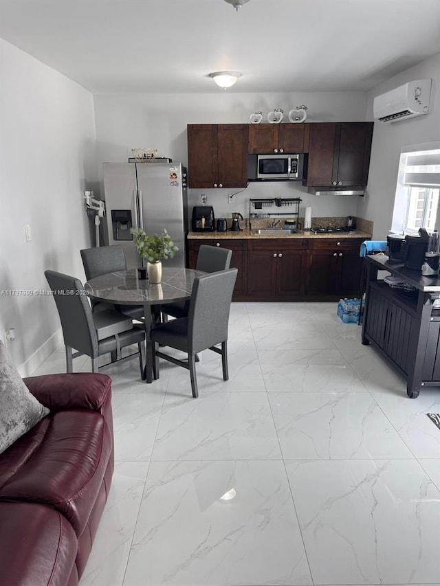 kitchen with dark brown cabinetry, a wall mounted air conditioner, marble finish floor, and appliances with stainless steel finishes