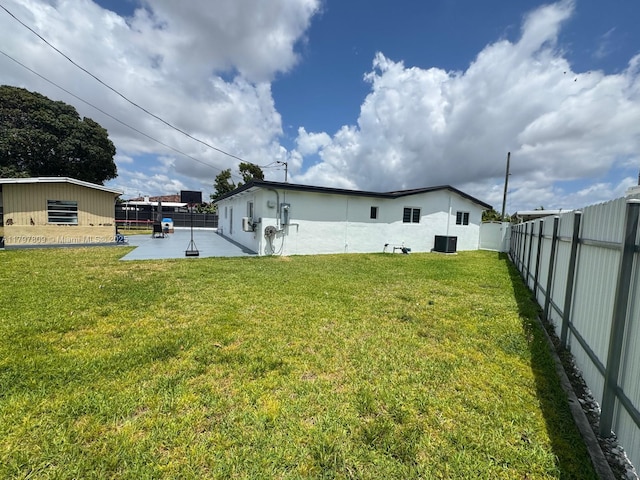 view of yard featuring a fenced backyard, a patio, and central AC unit