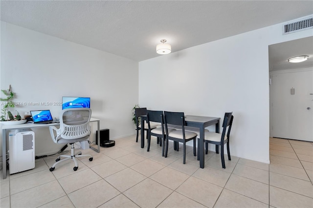5838 Collins Ave Unit 10E, Miami Beach, FL 33140 - dining space with light tile patterned floors, an office area, and a textured ceiling