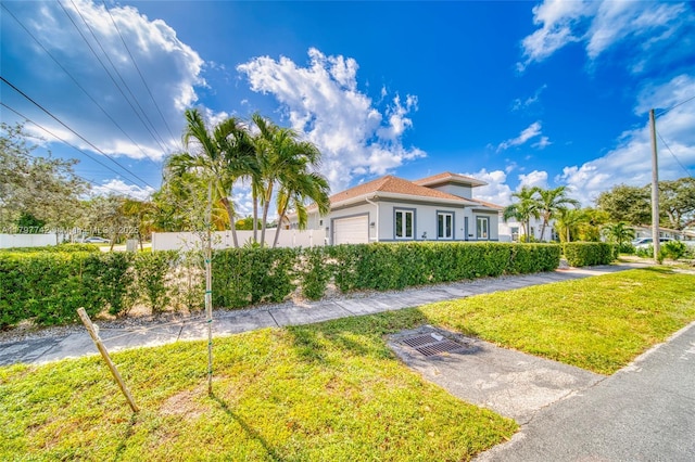 207 SW 11th St, Dania Beach, FL 33004 - mediterranean / spanish-style home with an attached garage, stucco siding, fence, and a front lawn