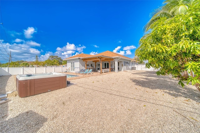 207 SW 11th St, Dania Beach, FL 33004 - back of property with a hot tub, a fenced backyard, a patio, a pool, and stucco siding