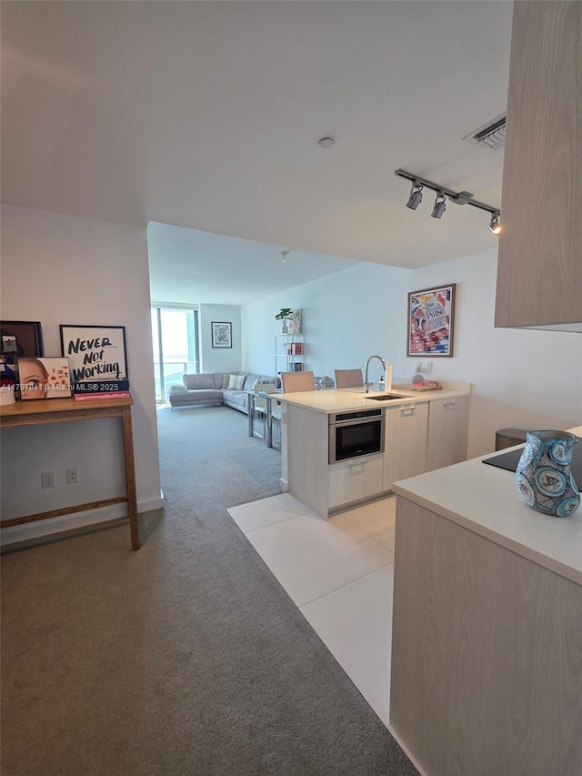 501 NE 31st St Unit 2802, Miami, FL 33137 - kitchen with track lighting, light colored carpet, light countertops, a peninsula, and open floor plan