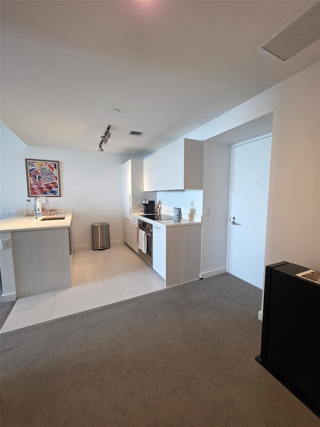 501 NE 31st St Unit 2802, Miami, FL 33137 - kitchen featuring oven, rail lighting, light countertops, and light colored carpet